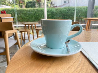 close up blue cup of hot coffee latte on wooden table