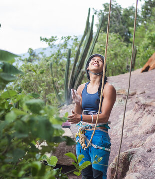 Happy female rock climber looking up, ready to climb