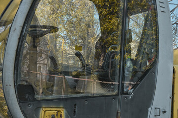 small excavator dug a trench in the ground in autumn background