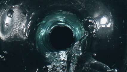 Liquid pouring clean vessel top view. Sparkling aqua flowing glass slow motion