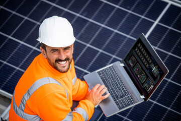 Solar panels installation for sustainable energy. Electrical engineer holding laptop computer with...
