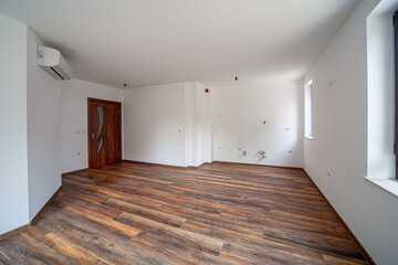 Empty bright living room. Beautiful apartment interior. Wooden floor.