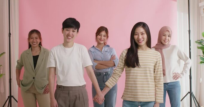 Asia people LGBT young adult Gen Z couple hold hand love care trust look at camera in Women's day studio shot pride month. Gay gender asian woman power unity cool team group happy smile photo shoot.