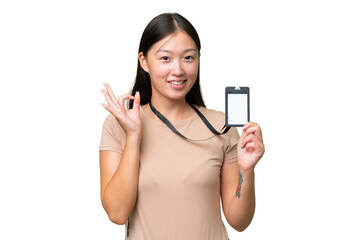 Young Asian woman with ID card over isolated background showing ok sign with fingers