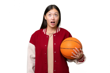 Young basketball player asian woman over isolated background looking up and with surprised expression