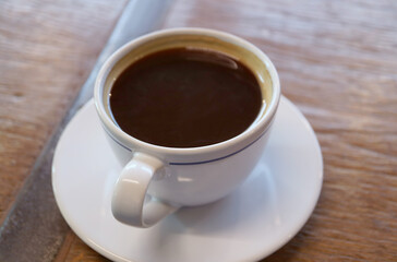 A cup of aromatic hot coffee isolated on wooden table