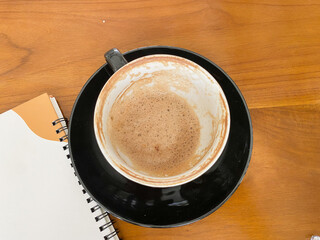 close up note book and chic empty black cup