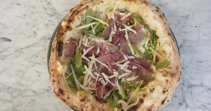 Closeup of pizza displayed on a marble table in a typical Italian restaurant in Paris.