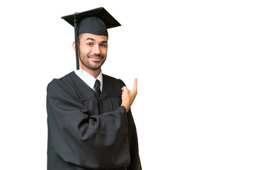 Young university graduate man over isolated background pointing back
