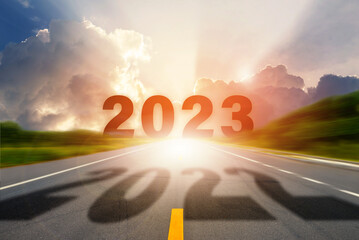 Go to the New Year 2023. Number 2022 of the old year on highway road in the middle and Number of...