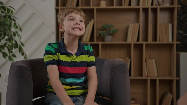 Kid working with speech therapist sitting on armchair in therapist office. Children speech-language pathologists at work.