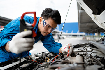 Auto mechanic concept.  Asian mechanics are using tools to check car safety in garage, maintenance...