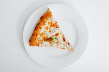 Top view one piece of cheese pizza on a white plate on the table. Food minimalism