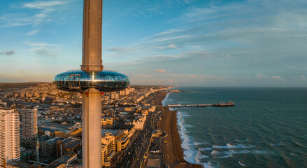 Magical sunset aerial view of British Airways i360 viewing tower pod with tourists in Brighton, UK...