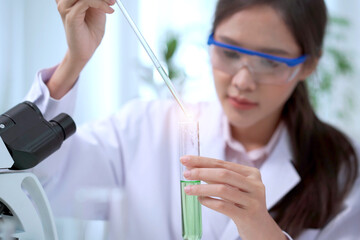 Team of biology researcher and scientist doing the biotechnology experiment in laboratory, scientist dropping a chemical or solution into the science sampling in a experimental tube.
