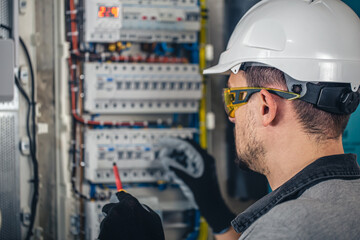 Man, an electrical technician working in a switchboard with fuses.