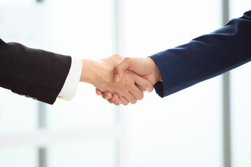 unrecognizable businesspeople doing a handshake together.