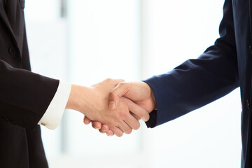 unrecognizable businesspeople doing a handshake together.