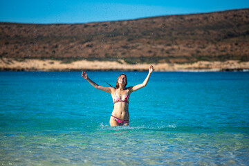 A beautiful girl plays in the turquoise water at ningaloo reef in cape range national park in western australia, swimming on a coral reef near exmouth