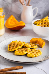 Pumpkin waffles on a plate on the table. Homemade baking. Vertical view
