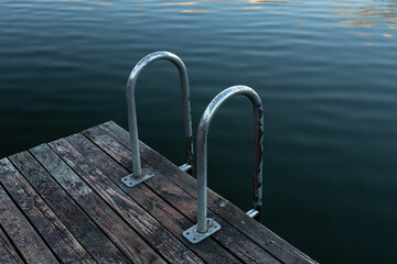 Wooden boards and water, masonry on the lake close-up.