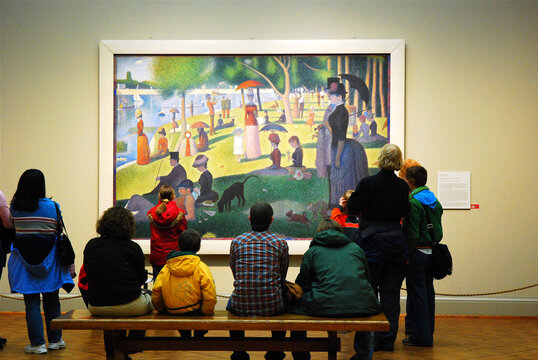 People sit and admire Georges Seurat's masterpiece Sunday Afternoon on the Island of la Grande Jatte at the Chicago Art Institute