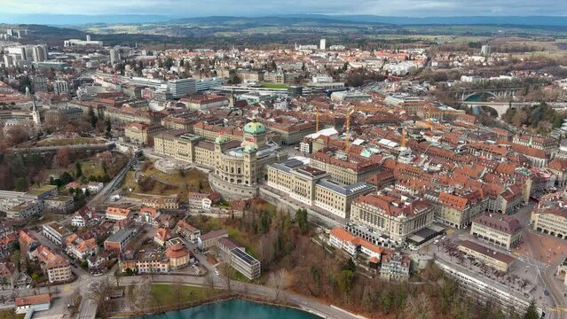 The Swiss Parliament Federal Government Building, Bundeshaus aerial footage in Bern. Capital city of Switzerland and Aare River ft. University of Bern and cityscape skyline view of Altstadt (Old Town)