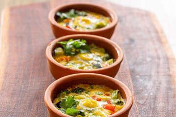 vegetables with quail eggs cooked in the single-portion earthenware bowl