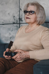 Fototapeta premium Portrait of a woman whose age doesn't bother her to feel young, playing with her mature daughter in video games spending time together. Rest, relax, coziness
