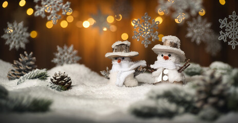 Christmas scene with snowman and hanging ornaments, wood background and snow, the illuminated brown...