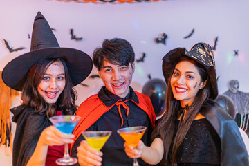 Asian young people in costumes celebrating halloween. Group of friends having fun at party in nightclub.