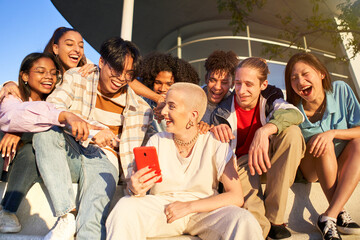 Multiracial people having fun together watching cell phone screens outdoors. Gen Z young students...