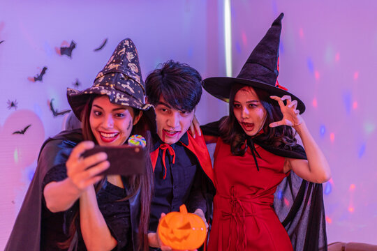 Asian young people in costumes celebrating halloween. Group of friends having fun at party in nightclub.
