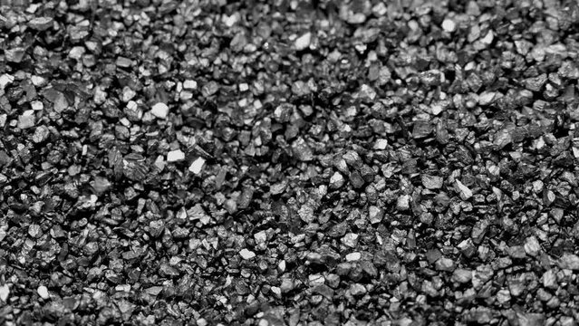 Black sand moving. Close-up of a black sand surface moving.