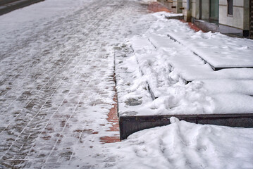 Stairs covered with snow, risk of falling on slippery stairs. Snow and ice covered stair case in...
