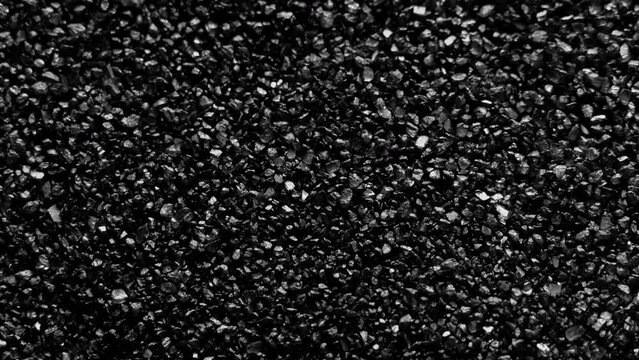 Black sand moving. Close-up of a black sand surface moving.