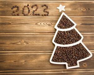 Happy New Year 2023. Christmas pine nuts in saucers in the form of a Christmas tree. Christmas wooden background