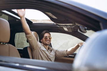 Handsome man driving his car in sand park © Petro