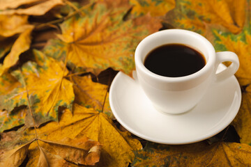 Autumn.Autumn leaves and a hot cup of coffee on a wooden table. Seasonal, morning coffee, Sunday relaxing and still life concept.Flat lay autumn composition.Autumn weekend mood concept.