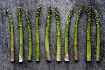 Green fresh raw asparagus on concrete background.Bunch of fresh asparagus top view on gray concrete background