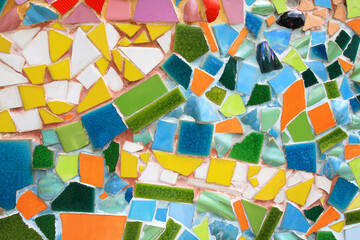 Colorful of mosaic tile floor for background. Art design wallpaper, Cracked, Shape and Abstract. Green, yellow, blue, white and orange tile fragments on wall.