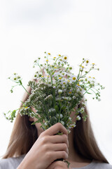 The girl is holding a bouquet that covers her face - 540746016