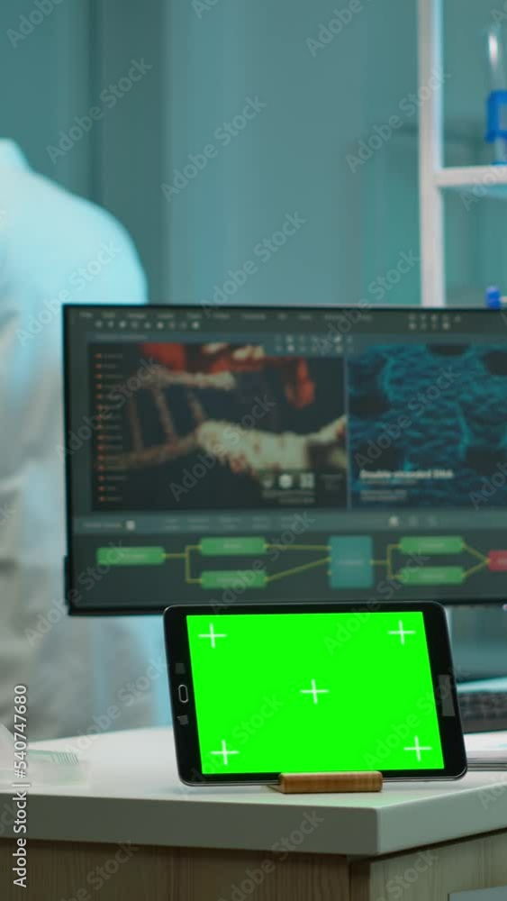 Poster vertical video: tablet with green screen working in labooratory with mock up, chroma key display whi