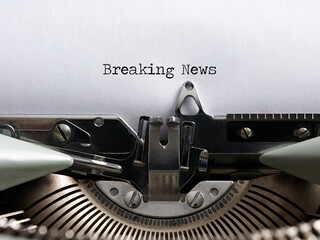 The word breaking news written with a vintage typewriter. Journalism, media information headline