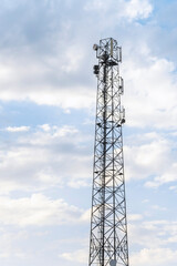 telecommunication tower with antennas and blue sky with clouds