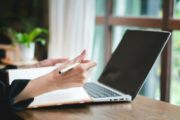 Lifestyle of female entrepreneur sitting at a modern coffee shop, businesswoman using laptop to communicate with partner to discuss her business via internet technology.