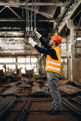 Man at steel factory standing by the hook crane