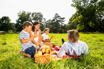 Happy authentic family having picnic and spending time together outdoor