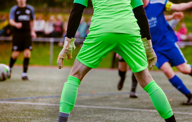 Goalkeeper in action. Rear view of Soccer Football Goalkeeper Goal on the Pitch During Match. 