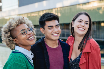 Happy multiracial friends having fun together outdoor - Focus on Asian guy face